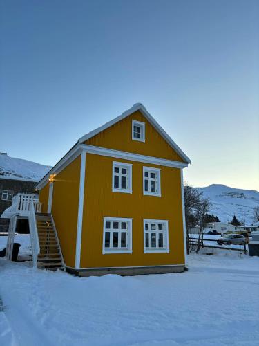 塞济斯菲厄泽Curry house rooms的前面有雪的黄色房子