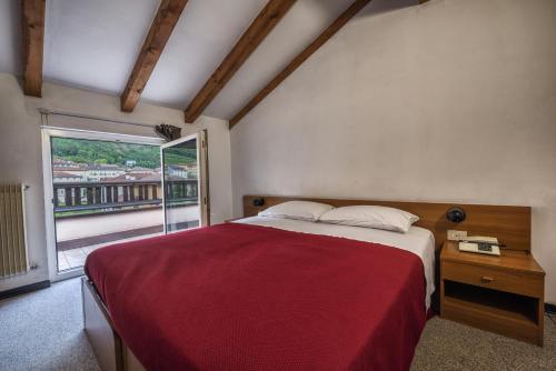 梅佐科罗纳德拉戈酒店的一间卧室设有一张大床和一个窗户。
