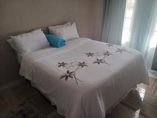 马翁Partulaka Rest Inn的一张床上的白色毯子,上面有鲜花