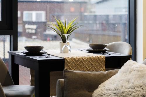 谢菲尔德Brand New Studio Apartment in Sheffield的窗前的桌子上放着两个碗