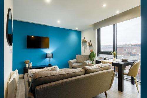 谢菲尔德Brand New Studio Apartment in Sheffield的带沙发和蓝色墙壁的客厅