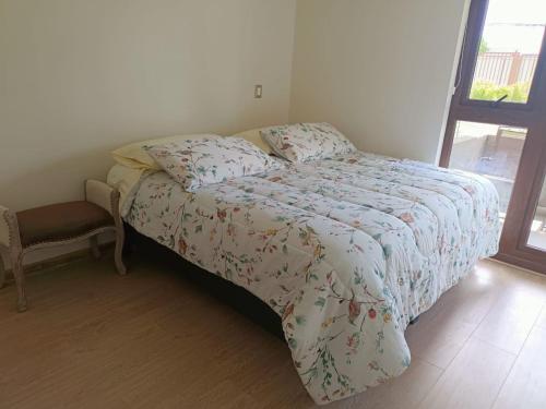 比亚里卡Departamento familiar Villarrica的卧室内的一张带被子和椅子的床