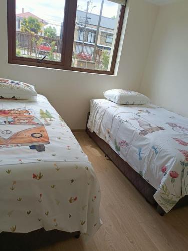 比亚里卡Departamento familiar Villarrica的两张睡床彼此相邻,位于一个房间里