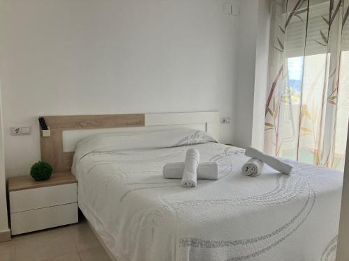 格拉德卡斯特利翁APARTAMENTO PINAPLAYA的白色卧室,配有带毛巾的床