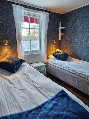 ÅkeröToppstugan的一间卧室设有两张床和窗户。