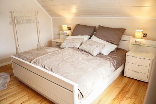 黑伦塔尔Ferienhaus Eifelwind Kamberg的卧室内的一张带两个枕头的床