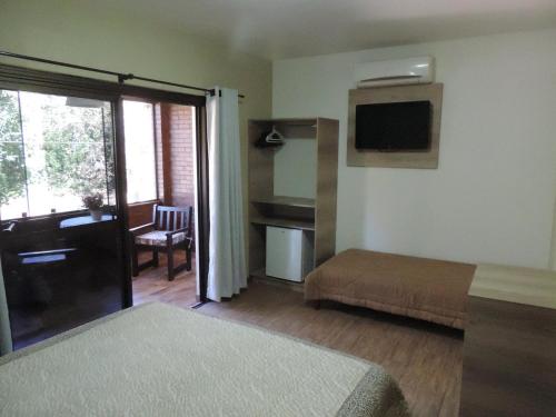 新彼得罗波利斯巴罗尼萨旅馆的客房设有带一张床和一张书桌的卧室。