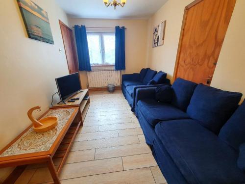 Grandes RocquesMas Des Sables Seaside Cottages的客厅配有蓝色的沙发和电视