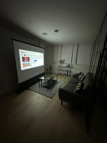 伦敦Stylish 1 Bedroom Apartment in Purley, Croydon的带沙发和投影屏幕的客厅