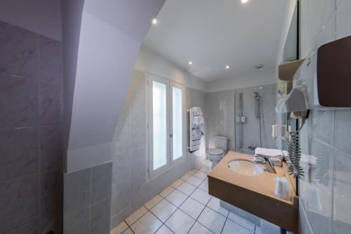 内里莱班Noemys Neris Montlucon - hotel restaurant的一间带水槽和卫生间的浴室