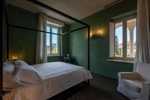 博尔戈塞西亚Villa Agnona Camere的一间卧室设有绿色的墙壁、一张床和椅子