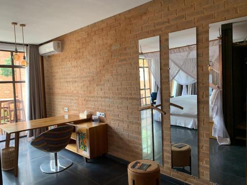 洛美天井旅馆的一间设有砖墙、书桌和床的房间