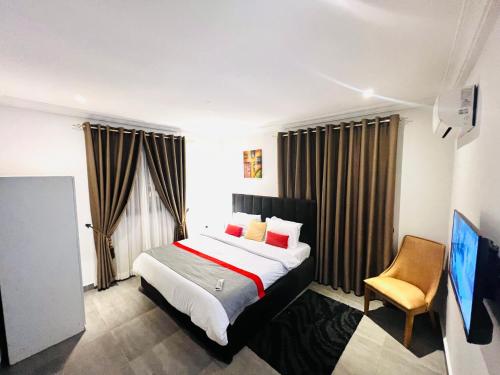 SunyaniKarjel Homes Apartments的配有一张床和一把椅子的酒店客房