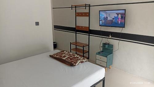 SiborongborongARIRANG27 HOMESTAY的一间卧室配有一张床,墙上配有电视