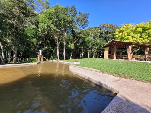伊克斯雷玛Pousada Moinho de Pedra的公园内的一个池塘,公园内有一个凉亭