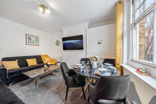 伦敦Chic Urban Retreat 1 Bedroom Gem in Covent Garden 3AB的客厅配有桌子和沙发