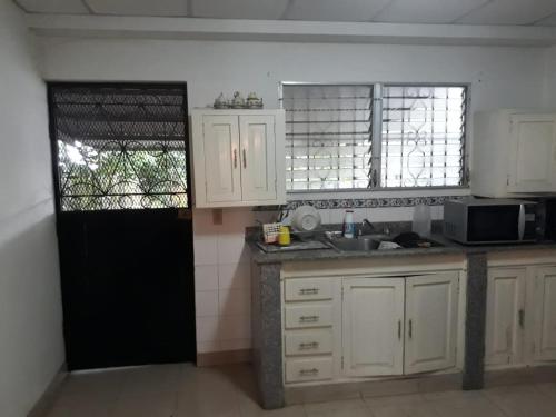 La Casa de Eyi的厨房配有白色橱柜和黑色门