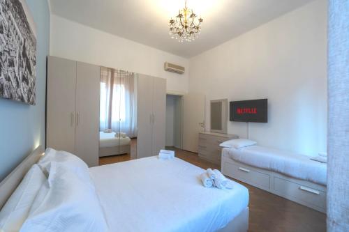 博洛尼亚Suite in the center of Bologna的一间卧室设有两张床,墙上挂着一个时钟。