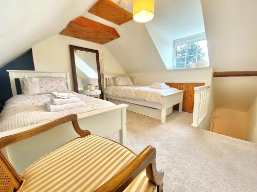 赫默尔亨普斯特德Bumblebee Cottage - Cosy Cottage in Area of Outstanding Natural Beauty的阁楼卧室配有两张床和镜子