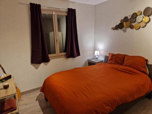 RamilliesChambre au calme à Ramillies - chez Ben的一间卧室配有橙色的床和窗户。