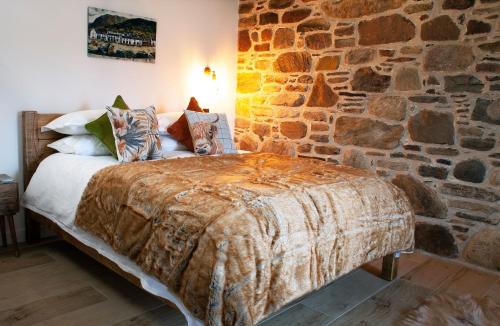 阿勒浦The Wreck - Lochside cottage Dog Friendly的石墙房间内的一张床位