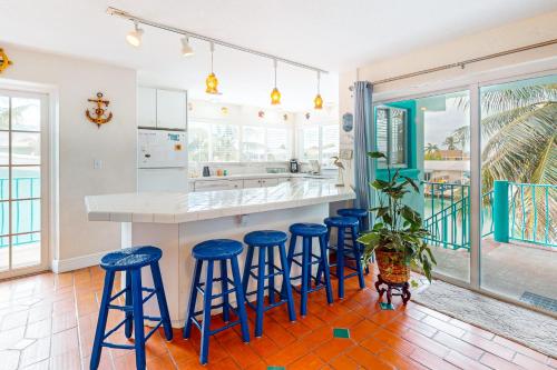 基克罗尼海滩Breezy Palms & Tropical Charm的厨房配有蓝色吧台凳和柜台。
