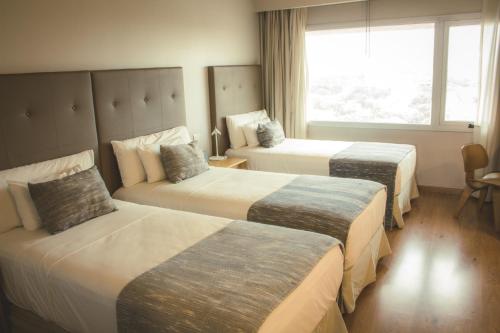 亚松森Dazzler by Wyndham Asuncion的酒店客房设有两张床和窗户。