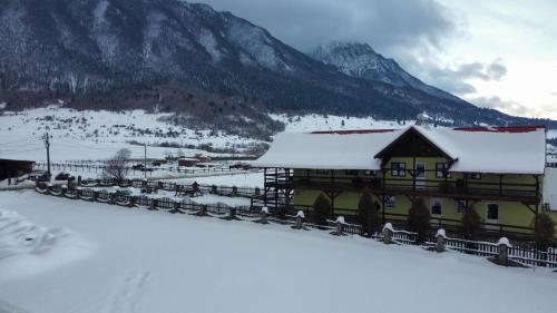 泽尔内什蒂Maricom Home的一座被雪覆盖的建筑,背景是群山