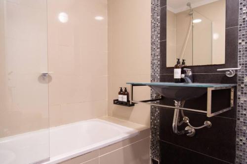 布宜诺斯艾利斯Malvon Beautiful Suite的浴室配有水槽、淋浴和浴缸。