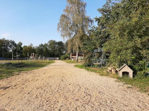 格尔利茨Urlaub auf dem Reiterhof am See in Görlitz的一条土路,旁边是一座房子