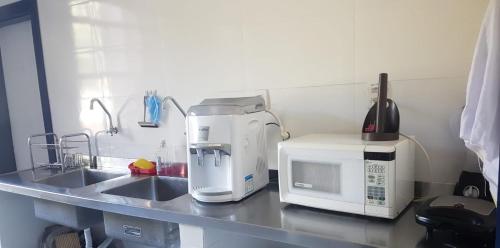 欧鲁普雷图A3EM Casa de Gorceix的厨房柜台配有咖啡机和微波炉