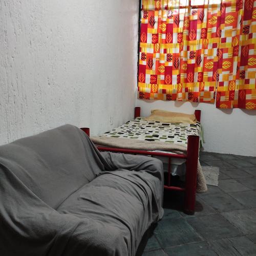 墨西哥城Casa ampliación piloto的床上和沙发,带窗帘的房间
