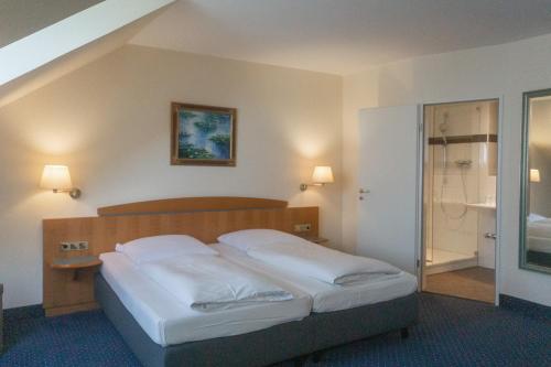 慕尼黑丹尼尔酒店的一间卧室配有白色床单