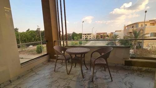 Sheikh ZayedMy Villa的阳台配有桌椅和窗户。