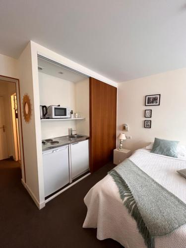 沙罗勒Le Téméraire Hôtel的一间卧室配有一张床和一个小厨房