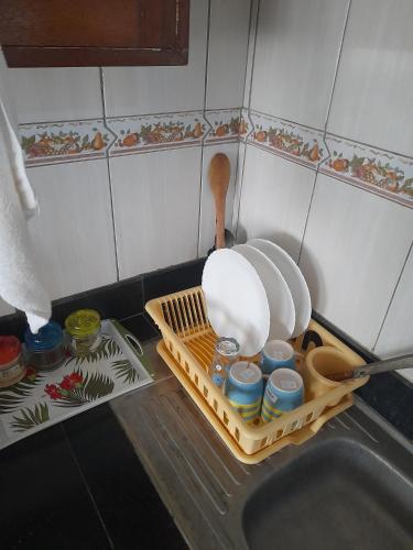 蒙巴萨Galene Abode Studio Apartment, Nyali的厨房水槽设有碗碟干燥架和餐具