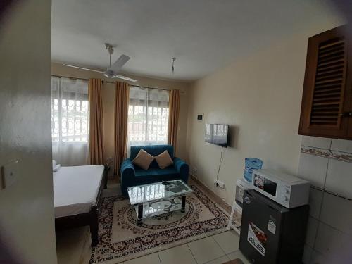 蒙巴萨Galene Abode Studio Apartment, Nyali的小房间设有蓝色的沙发和一张床