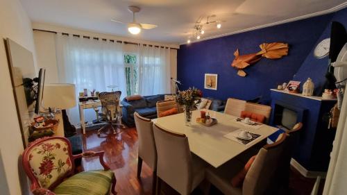 圣保罗SP Guest House的客厅配有桌子和蓝色的墙壁