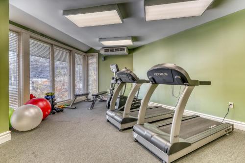 加特林堡巴斯金奎克温德姆度假公寓的一个带跑步机和健身器材的健身房,位于一个拥有绿色墙壁的房间