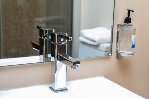 怀特霍斯SKKY酒店的浴室水槽和镜子前的水龙头