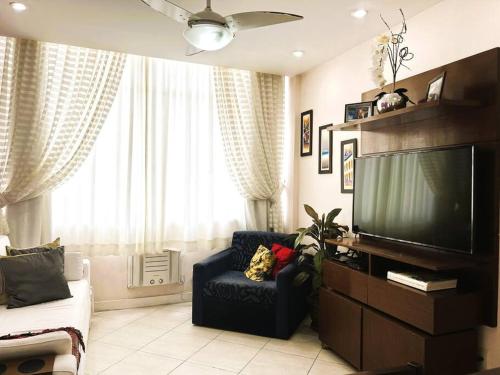 里约热内卢Charme do Leme的客厅配有平面电视和椅子。