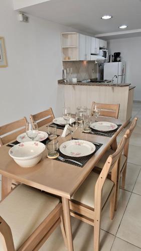 普洛缇尔Complejo Hunter Plottier - Neuquén的厨房里一张木桌,上面放有盘子和碗