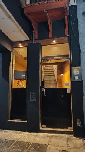 圣罗莎卡拉穆奇塔县Hostería Suites Del Centro的一座设有楼梯的建筑的开放式门