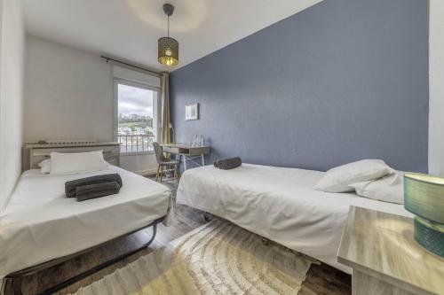泰昂维Appartement Les Oiseaux的一间卧室设有两张床、一张桌子和一个窗口