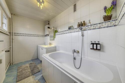 泰昂维Appartement Les Oiseaux的白色的浴室设有浴缸和水槽。