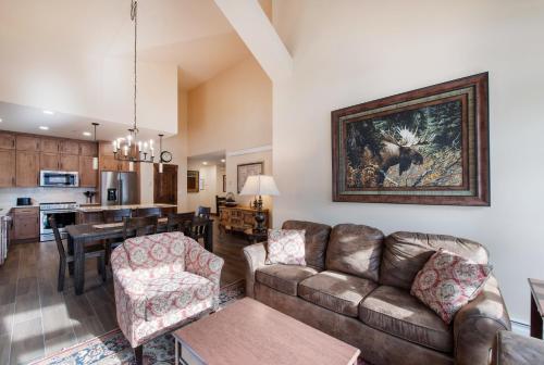 冬季公园Exquisite Zephyr Mountain Lodge condo with 2 king en suite's condo的客厅以及带沙发和桌子的厨房。