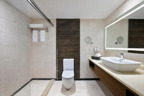 吉达Holiday Inn Jeddah Corniche, an IHG Hotel的浴室配有白色卫生间和盥洗盆。