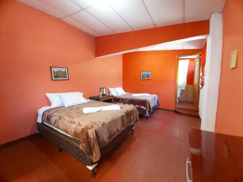 帕纳哈切尔Casa de Alondras的橙色墙壁客房的两张床