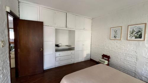 派桑杜Casa cabaña的一间卧室配有一张床和白色橱柜