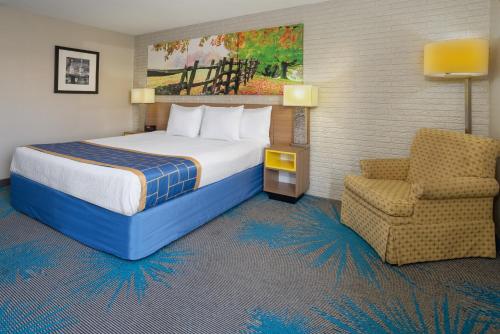 马纳萨斯马纳萨斯/66号州际公路戴斯酒店的配有一张床和一把椅子的酒店客房